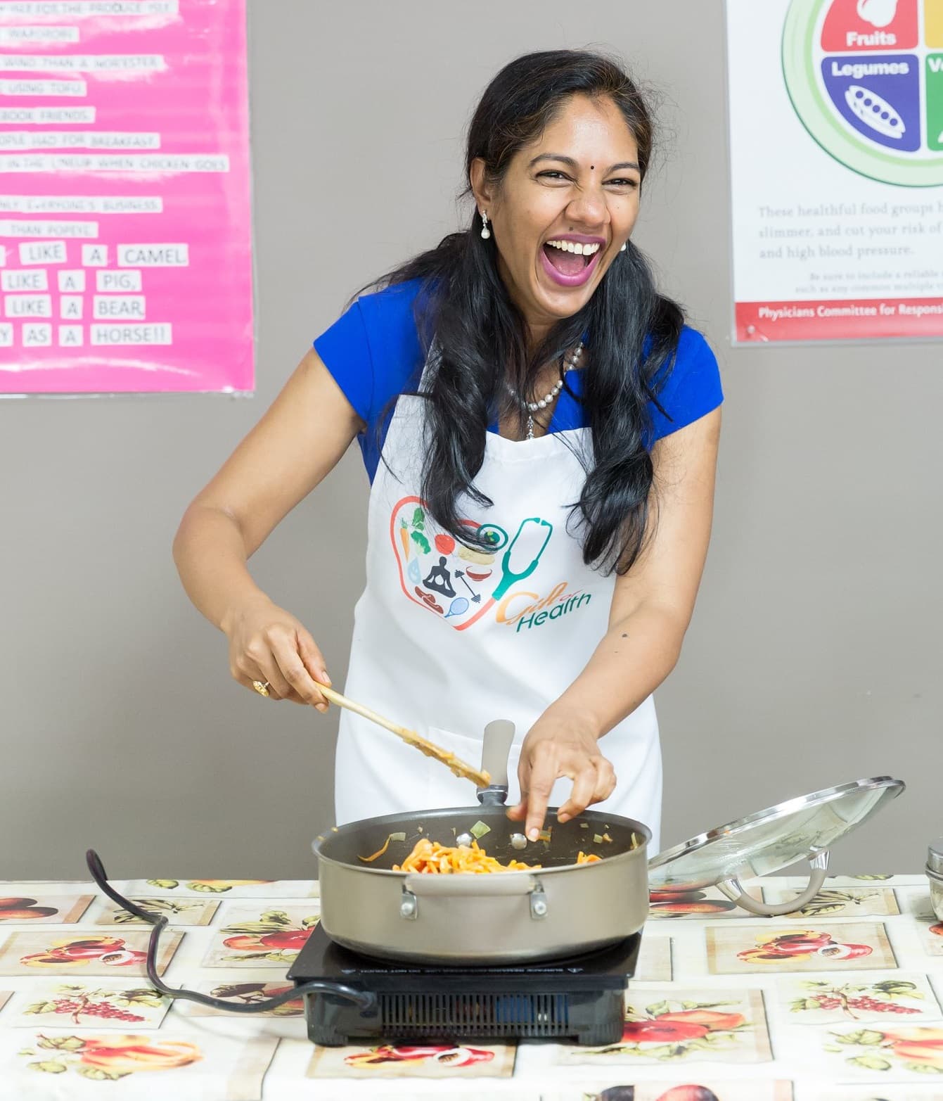 Woman joyfully cooking with a spatula.