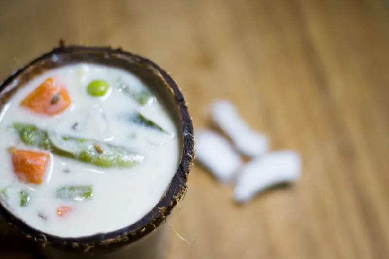 Coconut curry with vegetables in coconut shell.